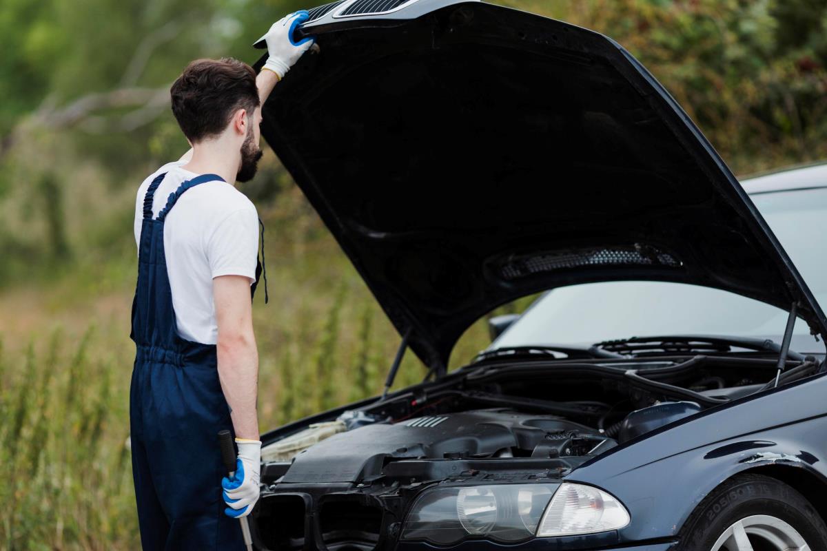 car mechanic opening a bonnet of a blue color car