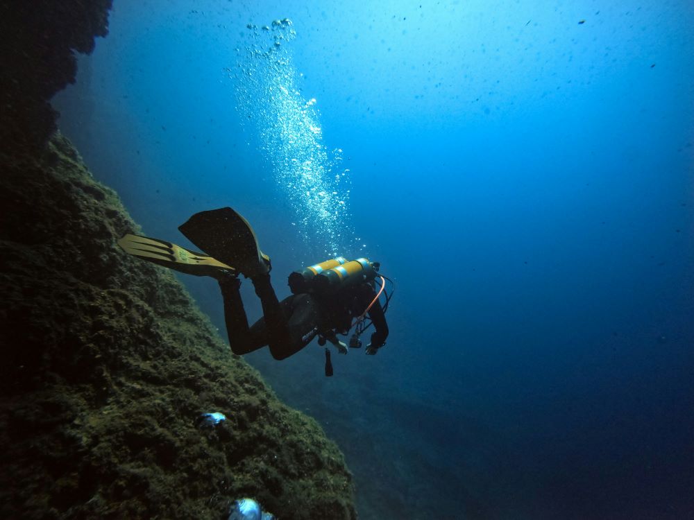 scuba diver swimming in suit