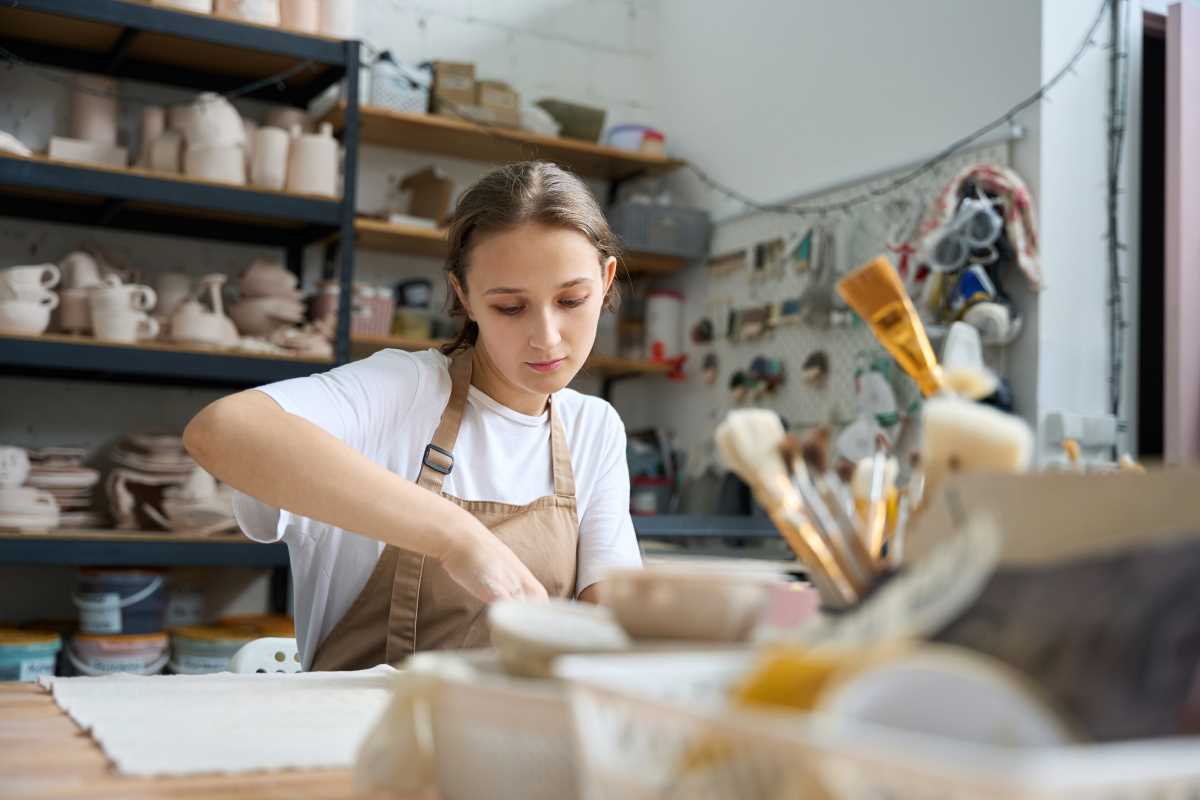 female student works at a table in a creative work