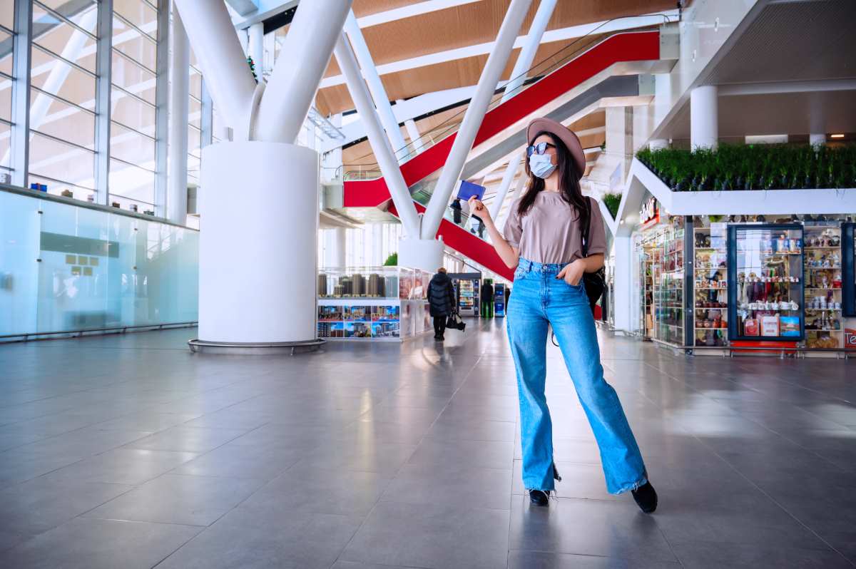 girl at the airport window waits for a flight