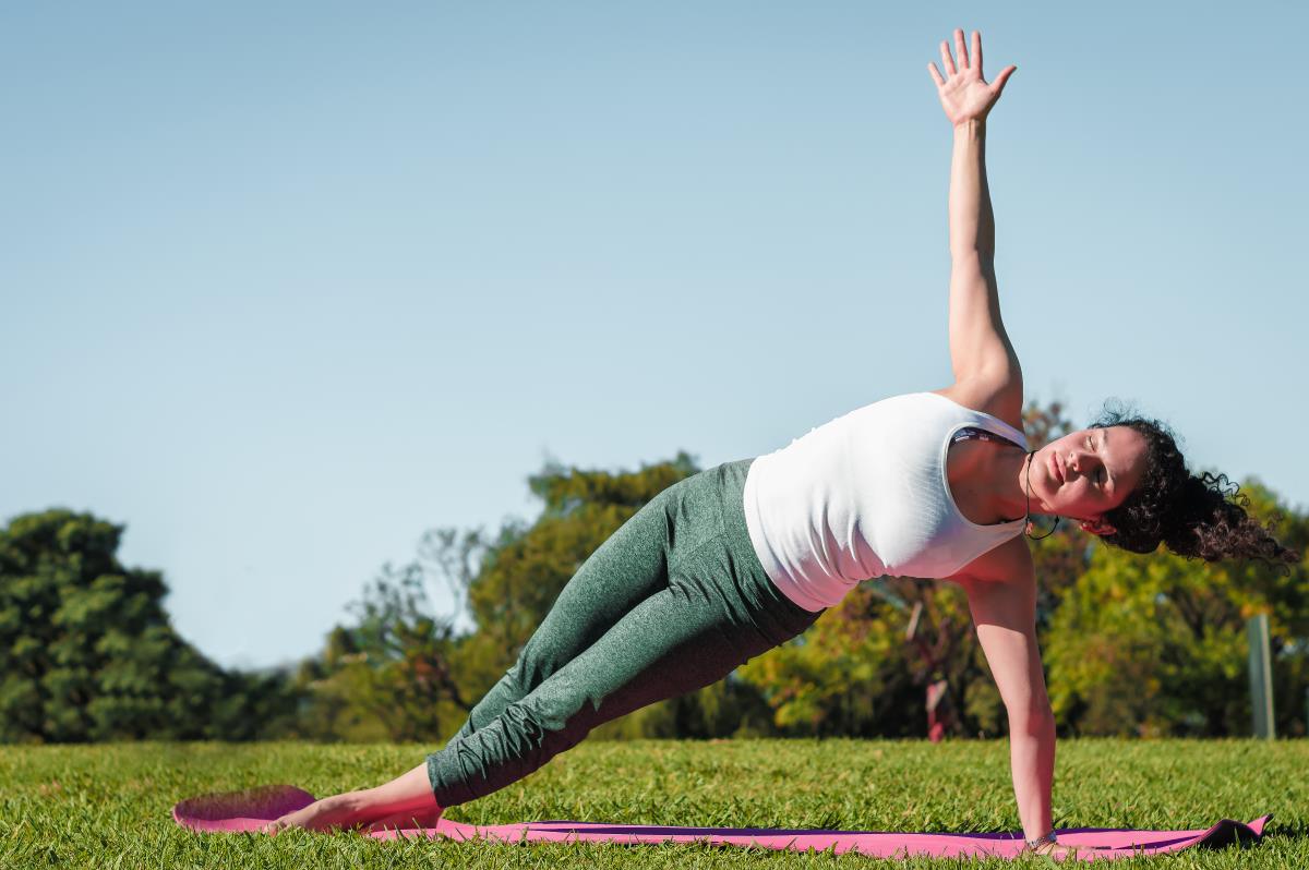 a teenage girl practising vasisthasana in the backyard during morning