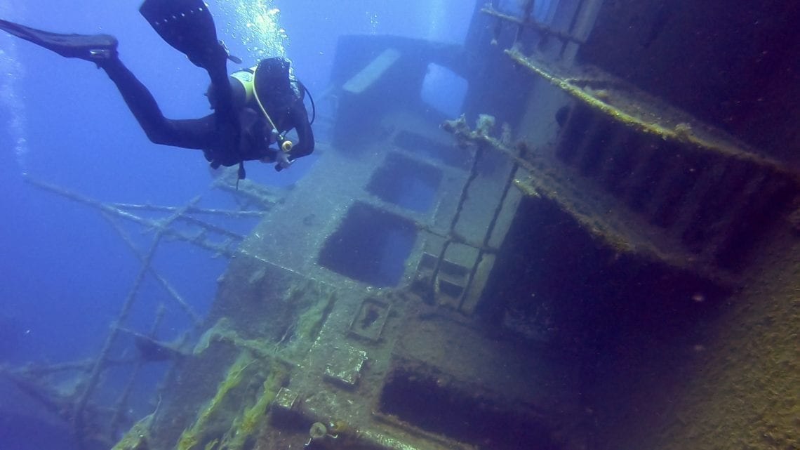 scuba diver getting to wrecked ship