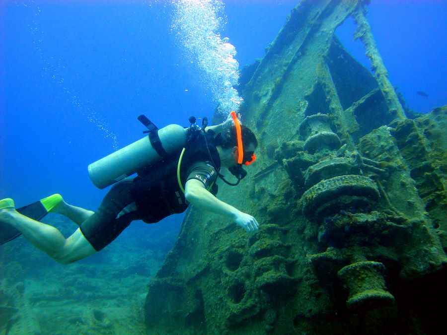 scuba diver looking at a old wrecked ship