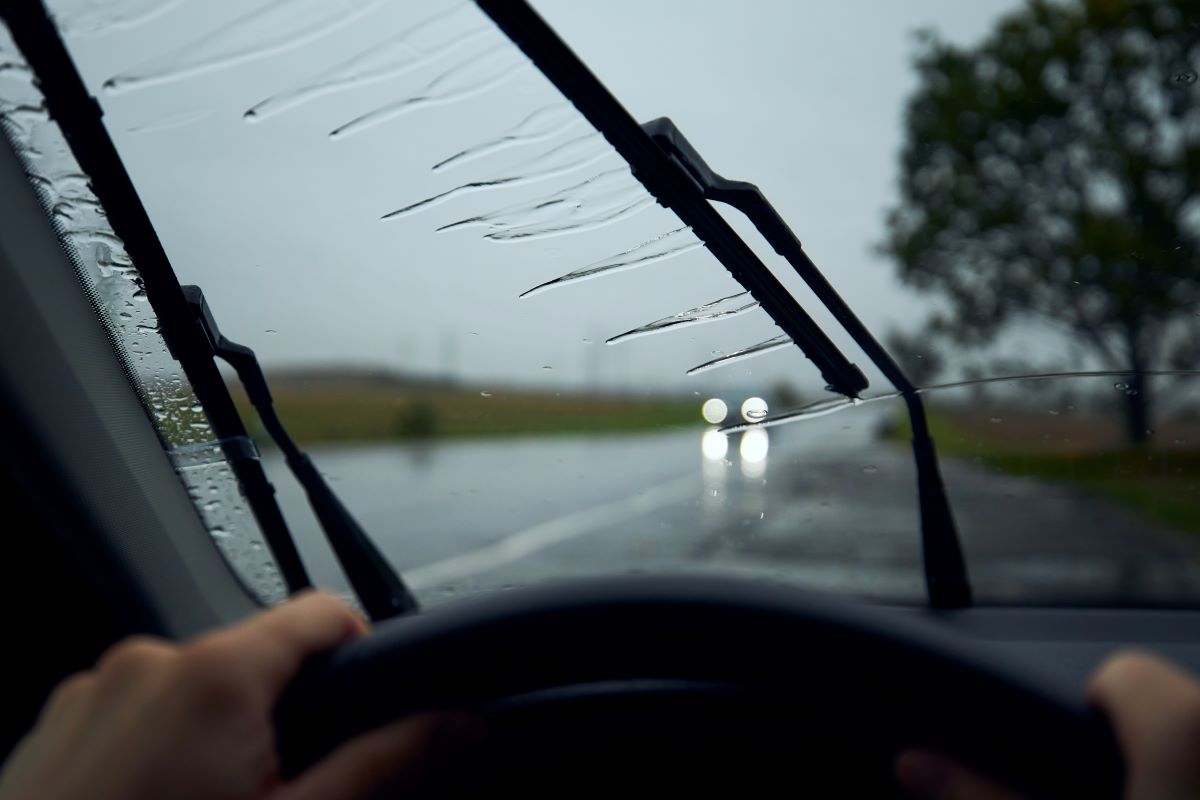 wipers wiping a car glass while driving a car in the rain