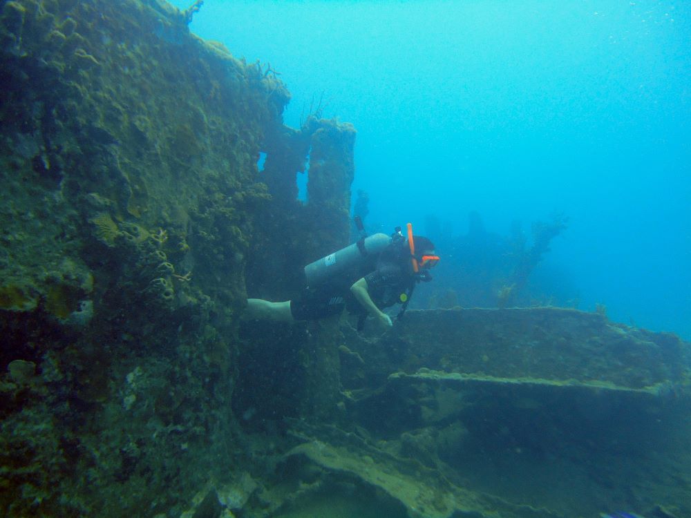 female scuba diver coming out from a cave under water