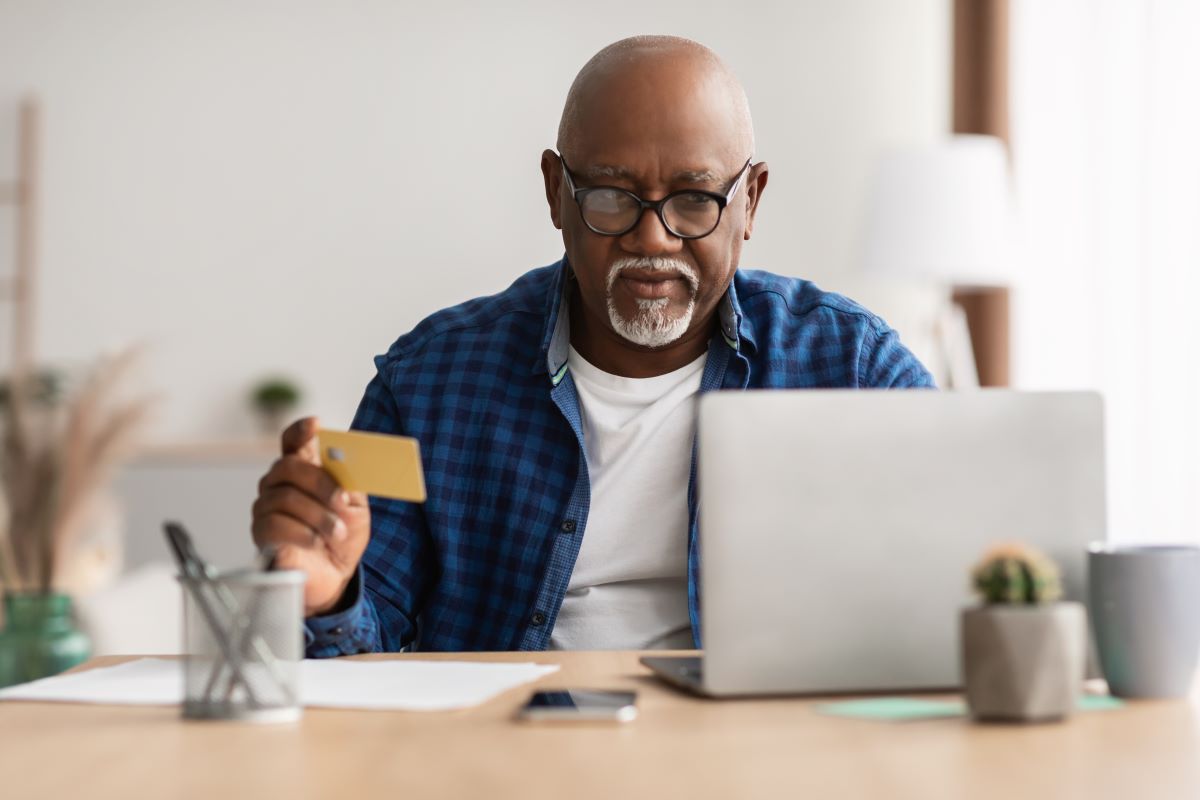 senior male doing online shopping using credit card