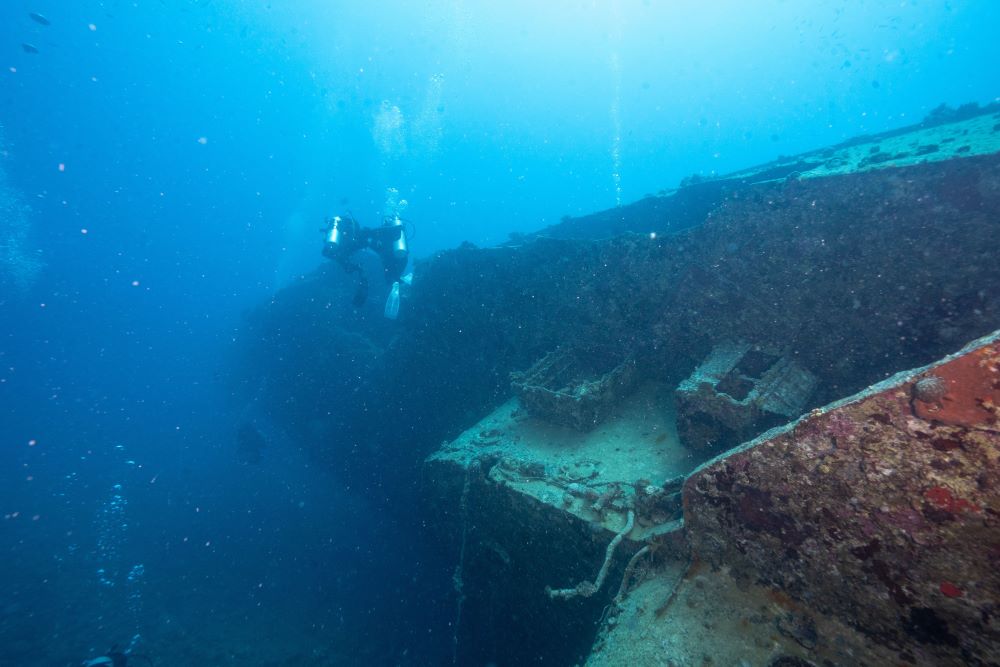 a scuba diver near to the old wrecked ship