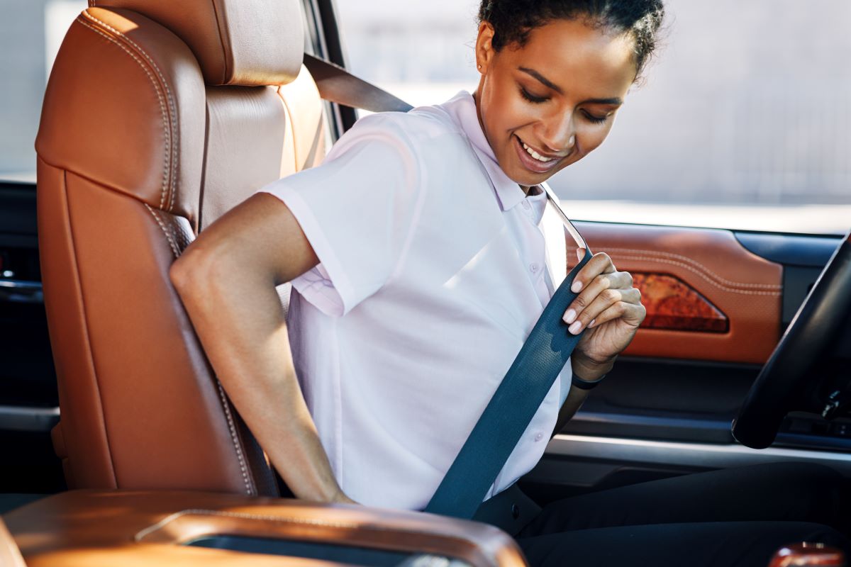 young business woman wearing her seat belt in a car
