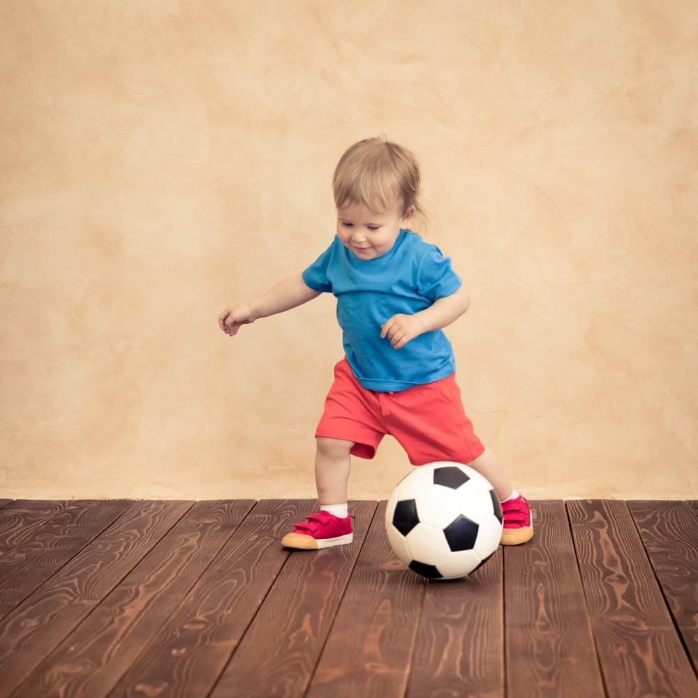 child kicking a football