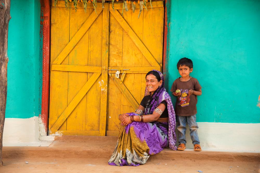 happy rural indian woman with postal life insurance