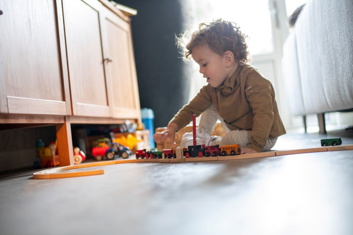 toddler playing with toy train